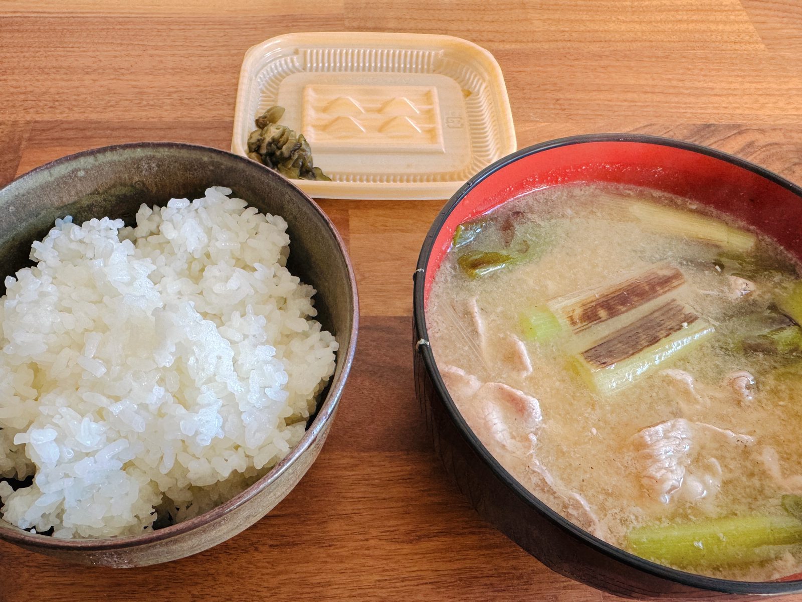 ごはんと具だくさんの汁物、漬物を並べた食卓
